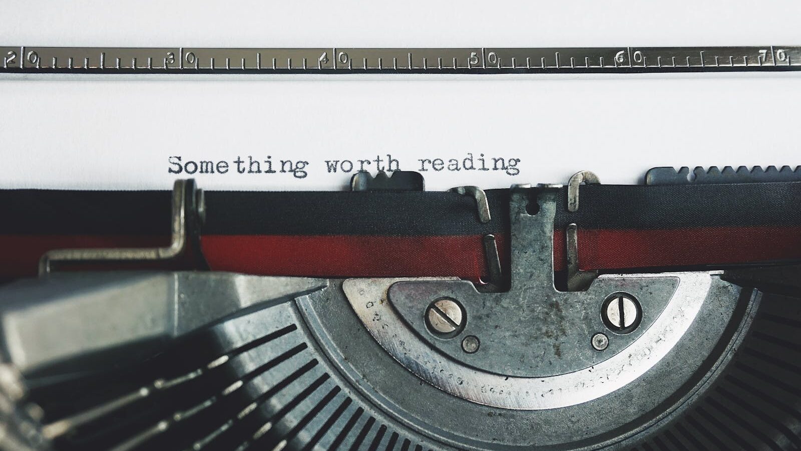 Close-up of a vintage typewriter with the phrase 'Something worth reading'.